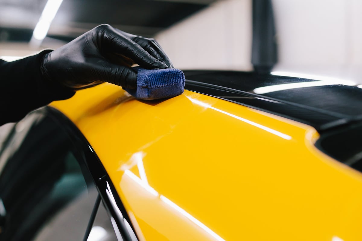 Applying ceramic coating to a sports car surface during a detailing session
